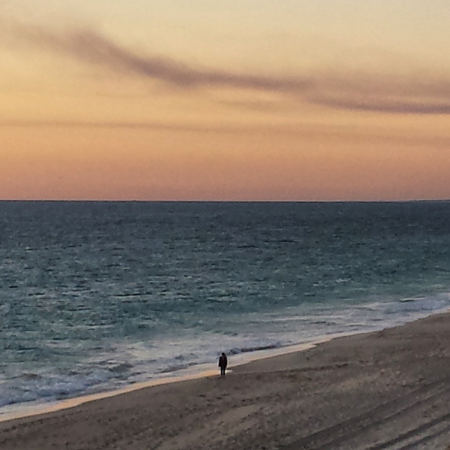 This lone figure strolls along the beach in Fremantle, Western Australia at dusk just as I was photographing the sunset.