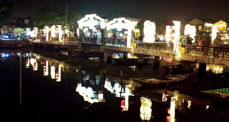 Hoi An at night and this bridge of lights and lanterns beckons the traveler across to the other side.